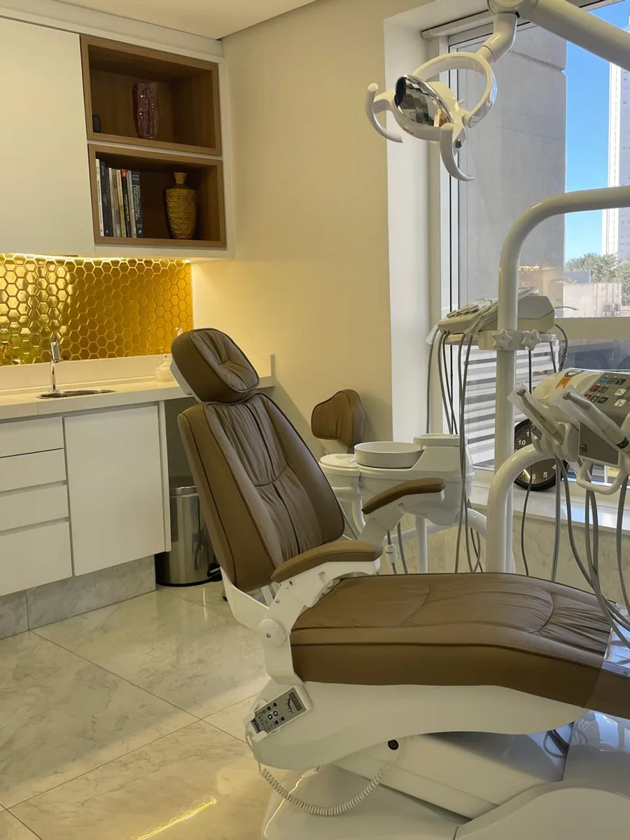 Cadeira odontológica e bancada com revestimento dourado